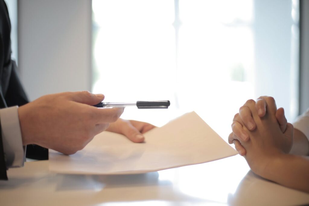 A person holding a pen over a paper