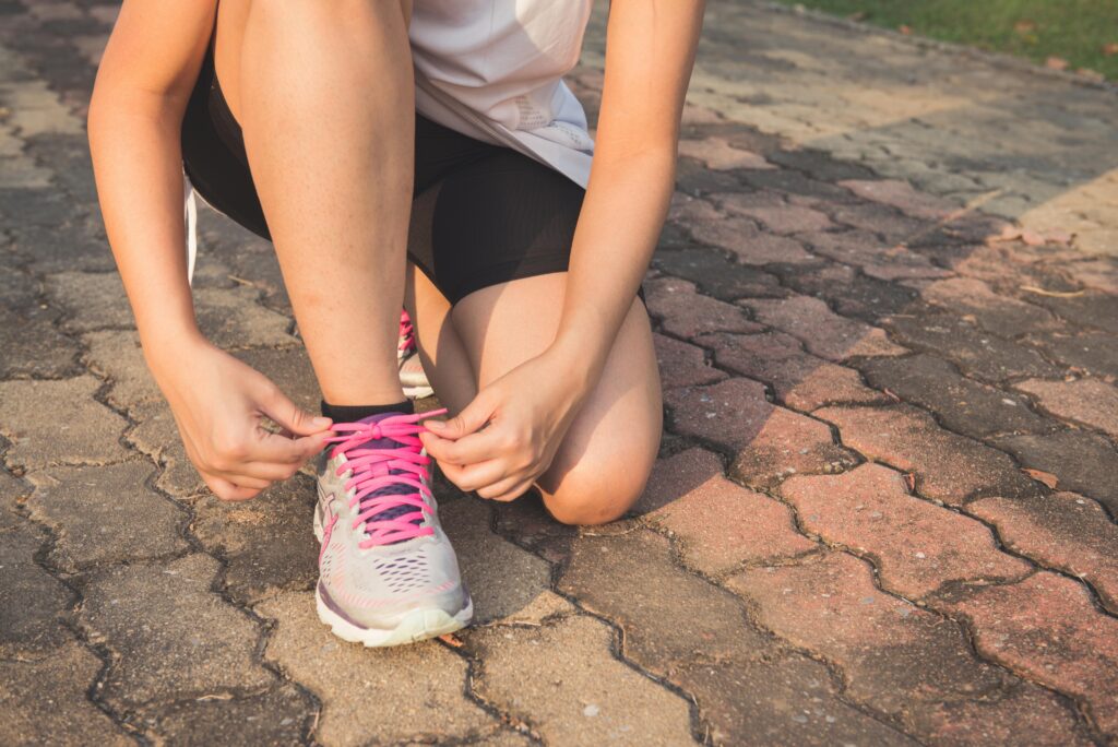  woman tying her shoelaces
