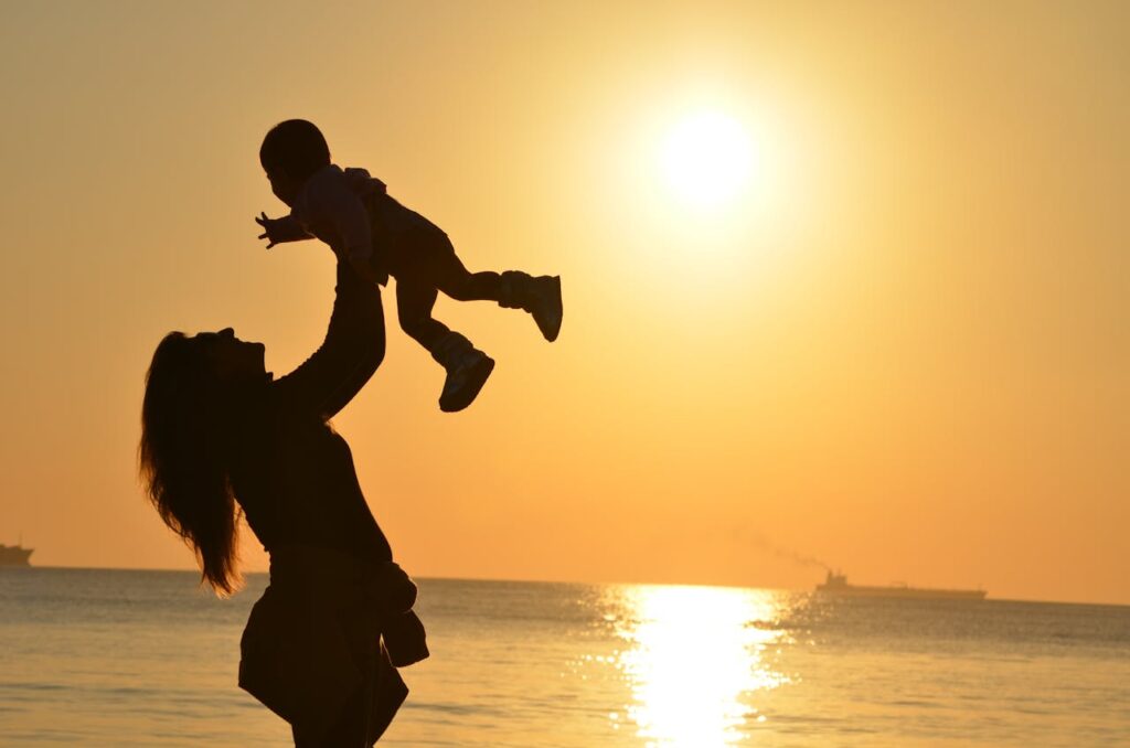a mother and child against sunset